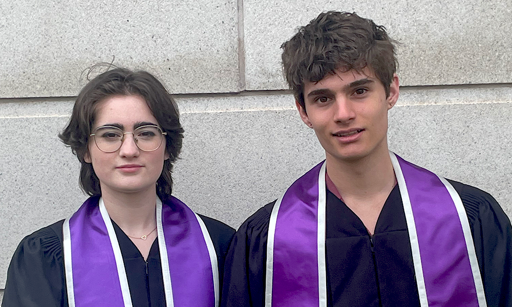 Music Performance alumni Robin Jackson and Cedric Van Exel stand together in their grad gowns and purple stoles.