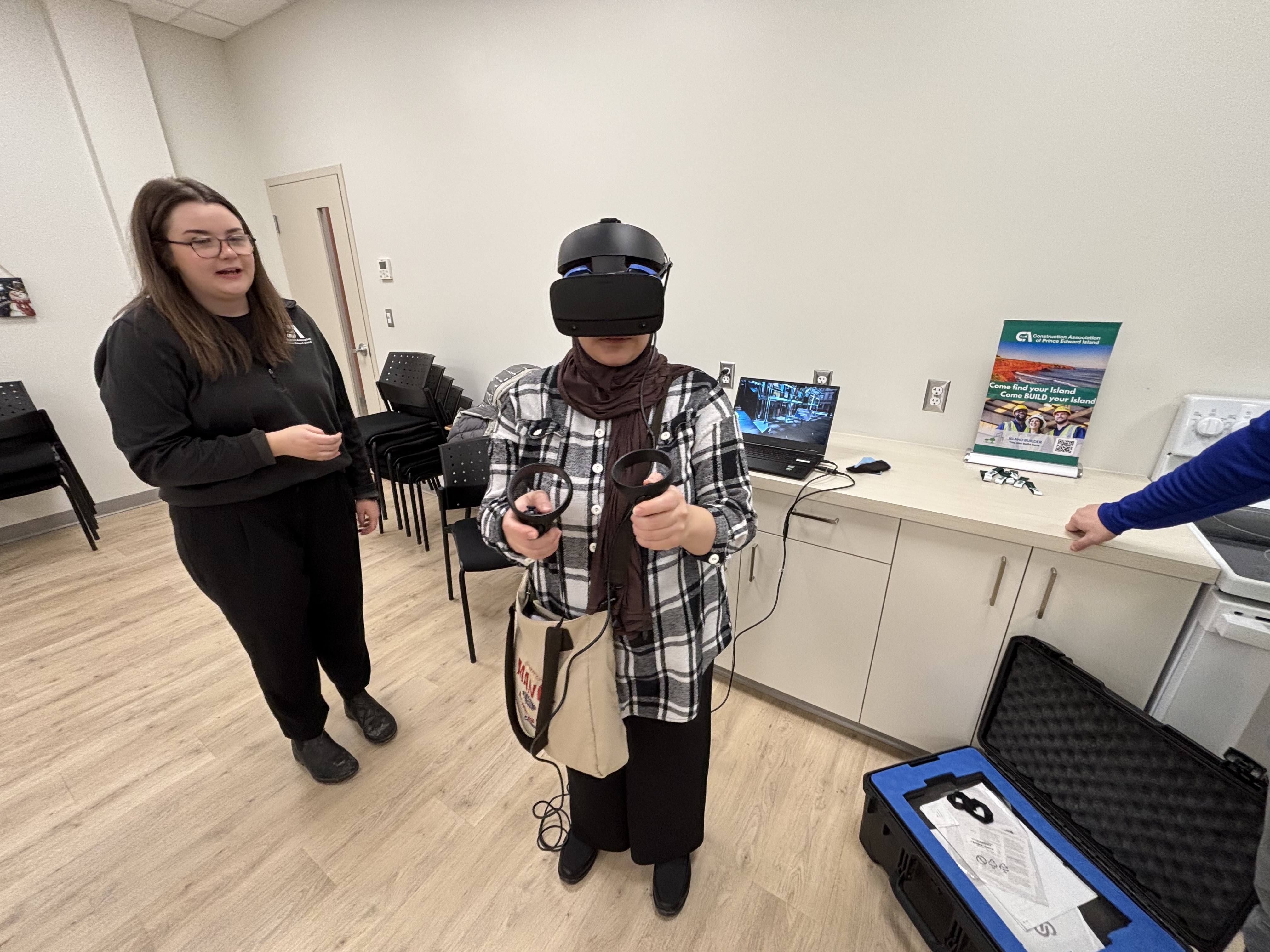 Samantha Campbell and Mah Ara Ahmadi from the Construction Association of PEI introduce students to various trade opportunities through a VR simulation. 