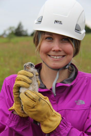 A smiling student poses with a newly banded bird